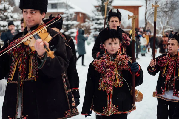 Kryvorivnia, Ukrajna - 2019. január 7.: Híres hutzulian Koliadnyky Kryvorivniából karácsonyi dalokat énekel és menetel az ősi fatemplom körül. A Kárpátok régi téli hagyományai. — Stock Fotó