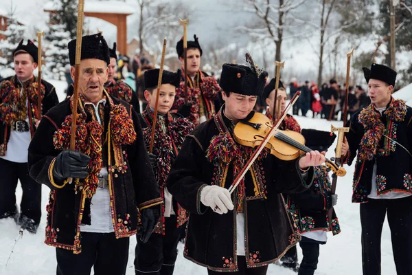 Криворивня, Украина - 7 января 2019 года: знаменитые гуцульские Колиадники из Криворивнии поют рождественские колядки и маршируют по старинной деревянной церкви. Древние зимние традиции Карпат . — стоковое фото