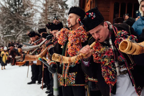 Kryvorivnia, Ukrayna - 7 Ocak 2019: Kryvorivnia 'lı ünlü hutzulian Koliadnyky Noel şarkıları söylüyor ve geleneksel trembita boynuzuyla çalıyor. - Evet. Karpatya 'nın eski kış tatili gelenekleri . Stok Fotoğraf