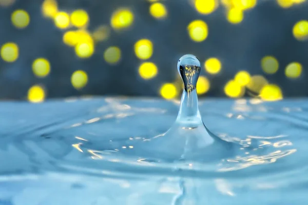 Water drops and Circle Ripples - Splash of light blue water with drops - a drop falling into the water