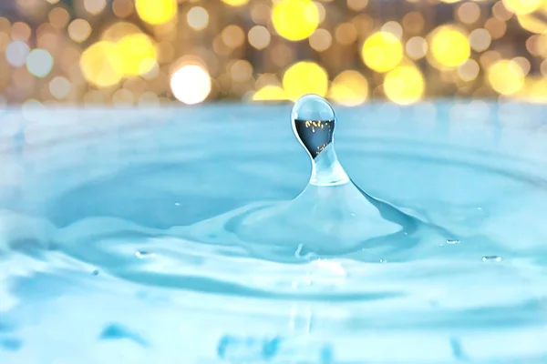 Water drops and Circle Ripples - Splash of light blue water with drops - a drop falling into the water