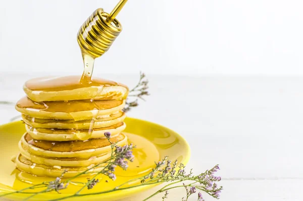 Pancake with honey flows down a stack of pancakes. Honey dripping down a pancake stack