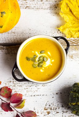 Krem ve tohumlar üzerinde ahşap bir masa ile kabak çorbası