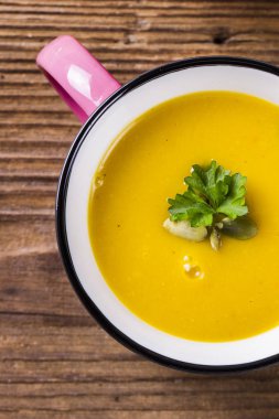 Emaye kupa vurdu, kabak çekirdeği ve maydanoz, yakın çekim balkabağı çorbası