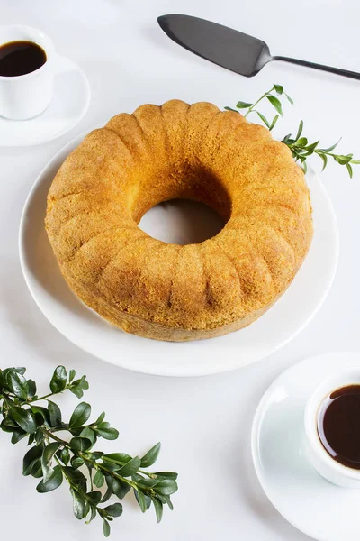 Zwei Tassen Kaffee, Bundkuchen und Buchsbaum auf einem weißen Tisch — Stockfoto