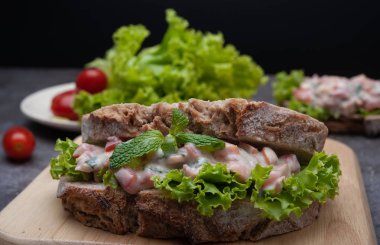 Domates ile sağlıklı kahvaltı sandviç, arka plan olarak gri tahta üzerinde marul