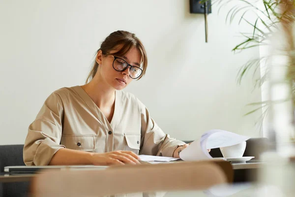 Sérieuse Jeune Femme Affaires Lunettes Examinant Les Documents Tout Buvant — Photo