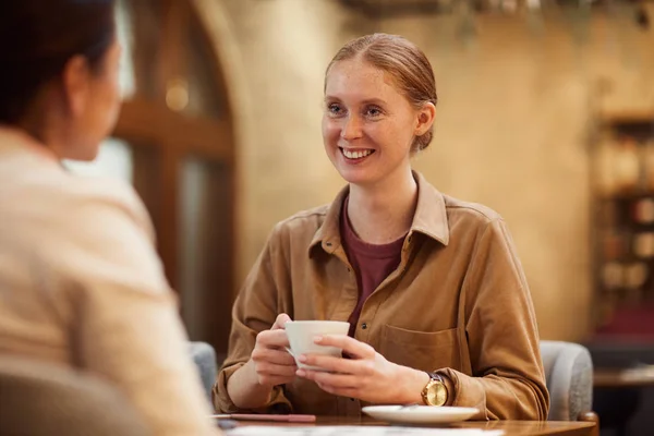 Jonge Vrouw Zit Aan Tafel Met Een Kopje Koffie Glimlachen — Stockfoto