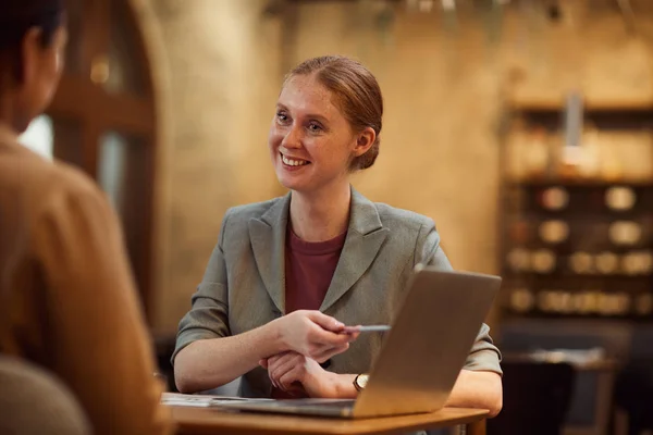 Fiatal Üzletasszony Mosolyog Rámutatva Laptop Megvitatása Online Előadás Kollégájával Kávézóban — Stock Fotó