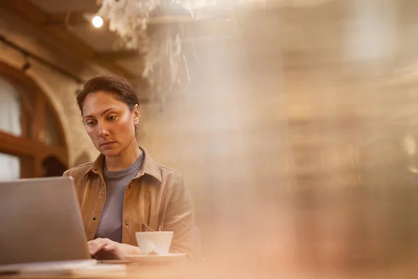 Серйозна Зріла Жінка Працює Ноутбуці Сидячи Столом Чашкою Кави Кафе — стокове фото
