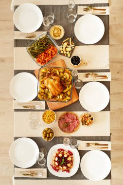 Yüksek açılı kızarmış hindi, sebze ve diğer yemekler servis edilen masada..