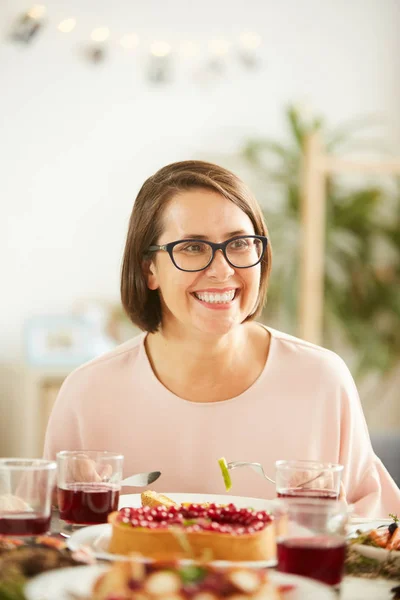 幸せな若いです女性で眼鏡で座っていると笑いながら夕食を持っています — ストック写真