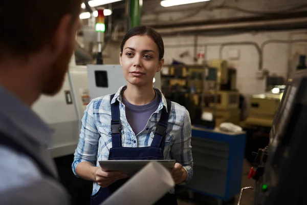 사업가는 디지털 태블릿을 공장에서 일하는 노동자에게 이야기하는 입는다 — 스톡 사진