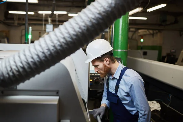 Junger Bärtiger Techniker Schutzkleidung Steht Neben Der Drehbank Und Kontrolliert — Stockfoto