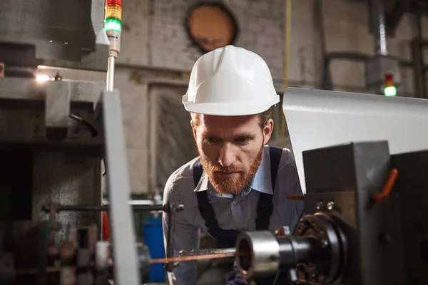 Serious Bearded Engineer Work Helmet Concentrating Work Watching Work Machine — 스톡 사진