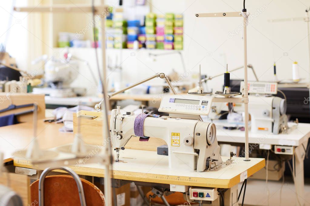 Modern sewing machines on work places in workshop