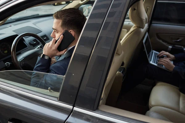 Νεαρός Επιχειρηματίας Μιλάει Στο Τηλέφωνο Και Οδηγεί Αυτοκίνητο Άλλους Επιχειρηματίες — Φωτογραφία Αρχείου