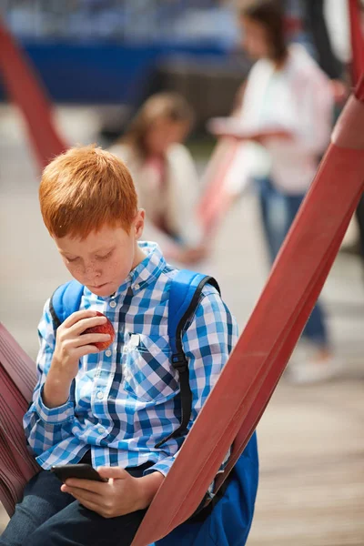 Écolier Aux Cheveux Rouges Qui Utilise Téléphone Portable Mange Une — Photo