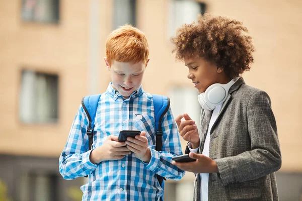 Deux Écoliers Tenant Debout Avec Des Téléphones Mobiles Pour Discuter — Photo