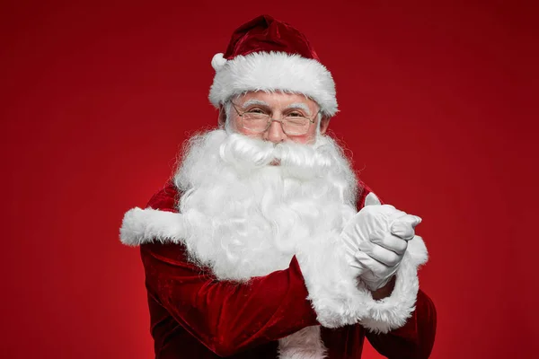 戴着眼镜 留着白胡子的圣诞老人的画像 对着红色背景的相机表示尊重和注视 — 图库照片