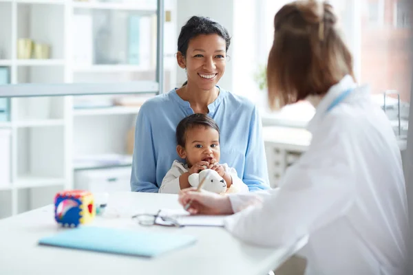 Lachende Jonge Moeder Zit Samen Met Baby Praat Met Arts — Stockfoto