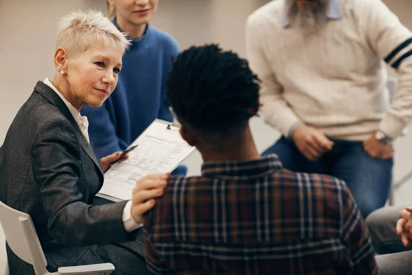 Reife Frau Mit Kurzen Blonden Haaren Hört Dem Jungen Afrikaner — Stockfoto