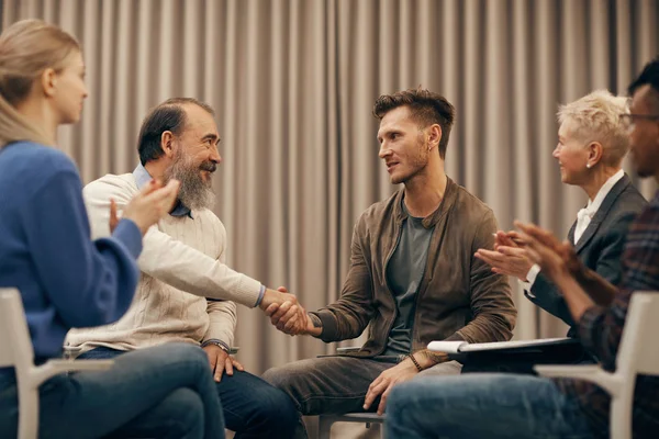 Two Men Sitting Shaking Hands Each Other While Other People — Stock Photo, Image