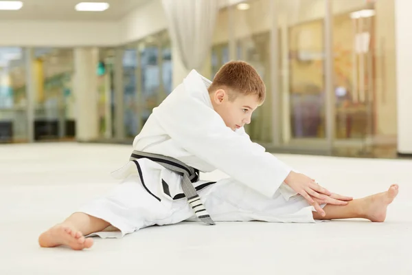 Kleine Jongen Draagt Witte Kimono Zittend Vloer Opwarmen Voor Training — Stockfoto