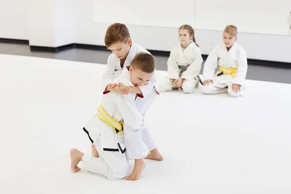 Twee Jongens Vechten Terwijl Andere Kinderen Zitten Vloer Kijken Tijdens — Stockfoto