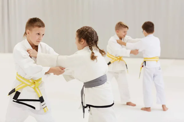 Gyerekek Csoportja Fehér Kimonóban Akik Technikákat Gyakorolják Karate Oktatás Során — Stock Fotó