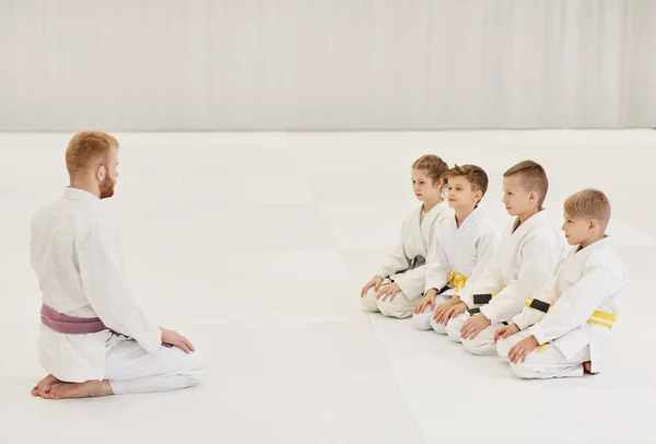 Fiatal Edző Padlón Beszél Csoporttal Karate Óra Alatt Tornaterem — Stock Fotó