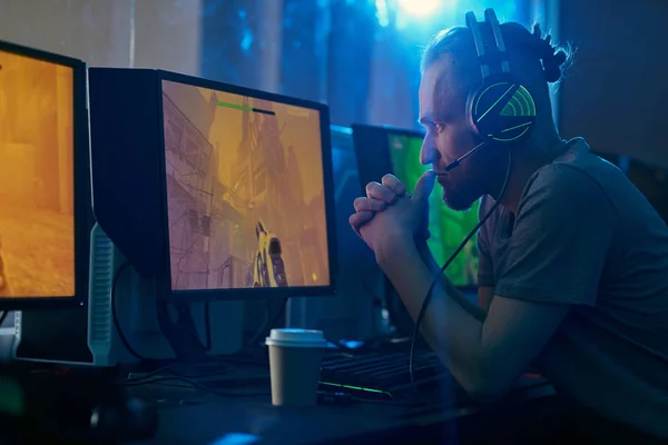 Joven Con Auriculares Sentado Frente Monitores Ordenador Mirando Pensando Estrategia — Foto de Stock