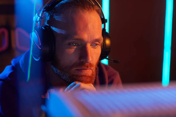 Young Bearded Man Wearing Headphones Looking Computer Monitor Pensive Sight — Stock Photo, Image
