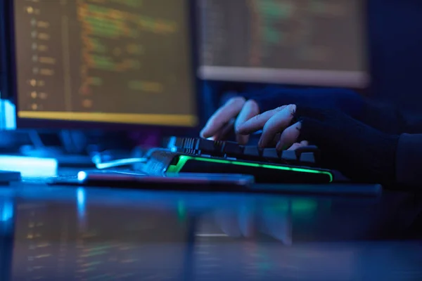 暗いオフィスのテーブルでコンピュータのキーボードを入力黒手袋を身に着けている男のクローズアップ — ストック写真