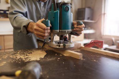 Çalışırken elektrikli testere kullanan işçiler