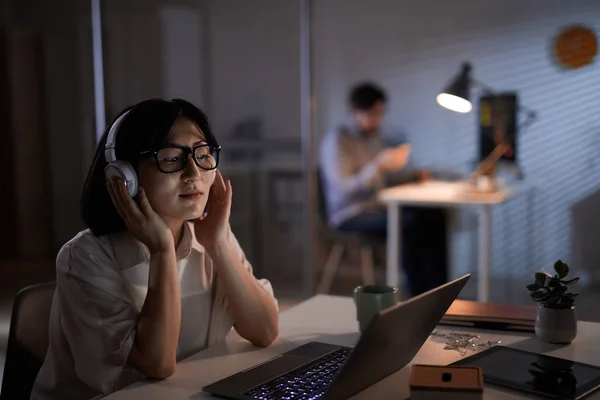 Empresaria usando auriculares en su trabajo — Foto de Stock