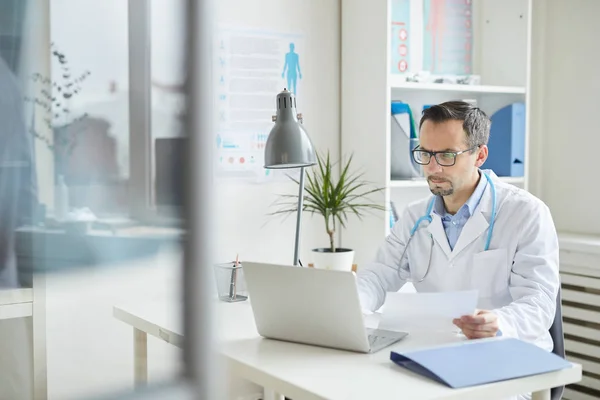 Doctor trabajando en el ordenador portátil en la oficina —  Fotos de Stock