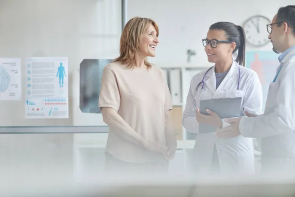 Gelukkige patiënt in gesprek met artsen — Stockfoto