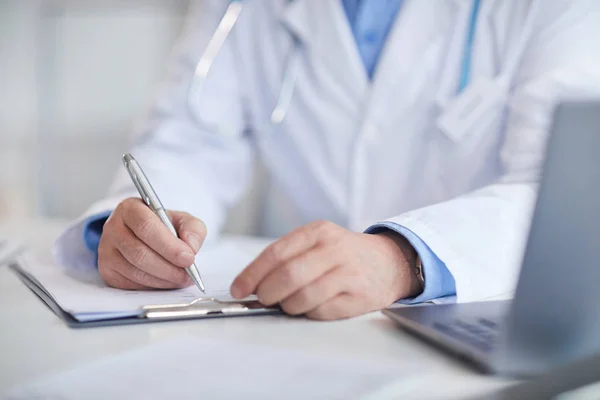 Doctor filling medical card — Stock Photo, Image