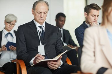 Seminerde çalışan kıdemli işadamı.