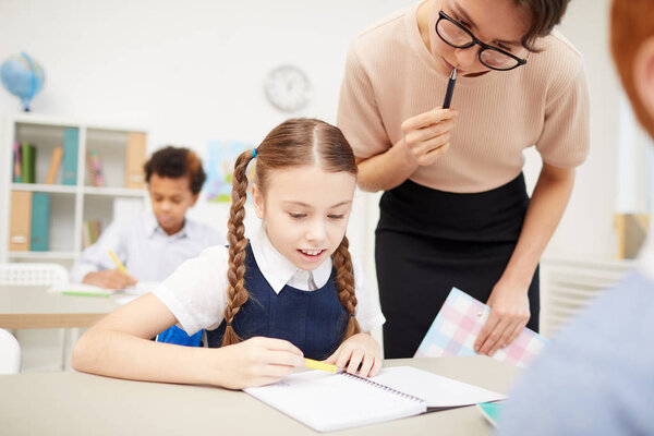 Schoolgirl consulting with teacher