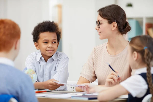 Professor trabalhando em conjunto com os alunos — Fotografia de Stock