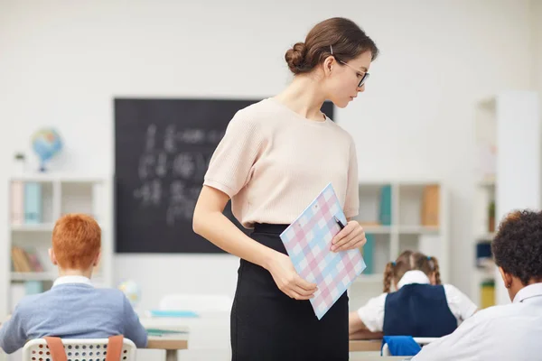 学校で子供たちと働く女性 — ストック写真