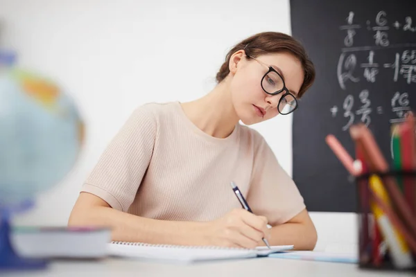 Young teacher working at the table in the classroom — Stock Photo, Image