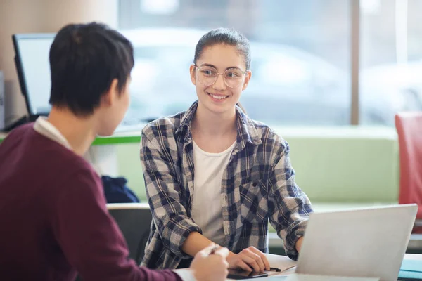 Jonge vrouw werkt op laptop met collega — Stockfoto