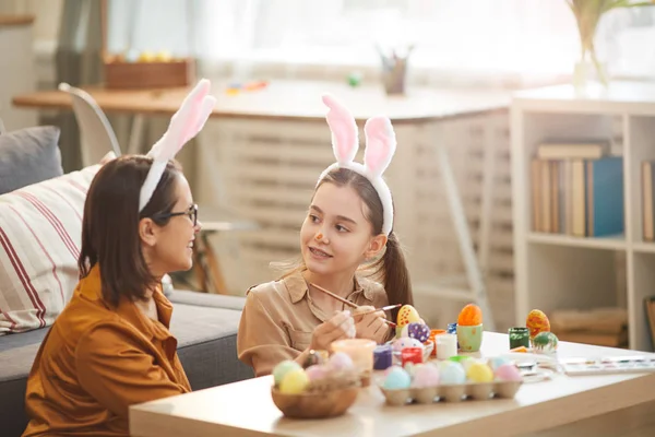 Girl painting eggs with mother — ストック写真