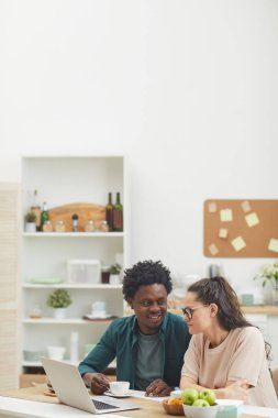 Mutfakta dizüstü bilgisayar kullanan çift.