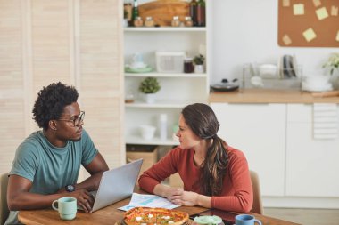 Gençler evde yemek yiyor.