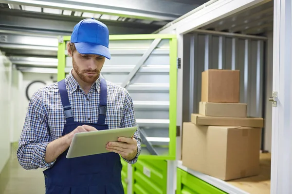 Worker using tablet pc in warehouse — Stock Photo, Image