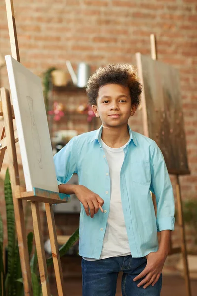 African boy standing near the easel — Stok fotoğraf